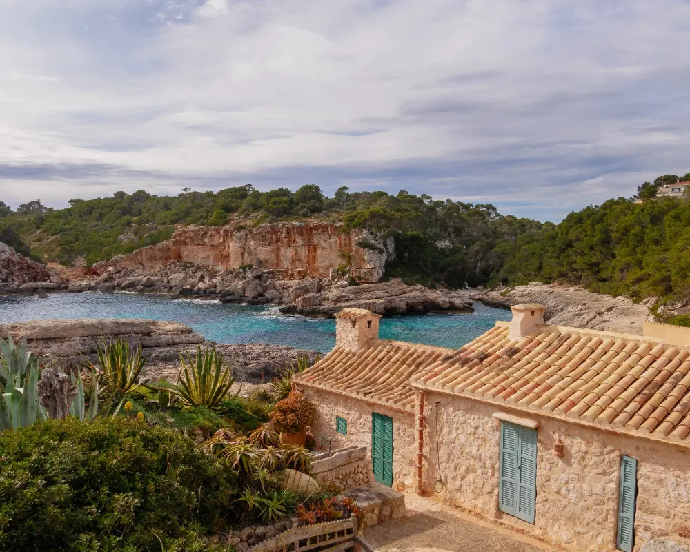 Traditionelle mallorquinische Finca an einer Bucht mit türkisem Wasser