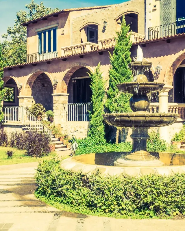 Villa mediterránea con fuente y bojes recortados